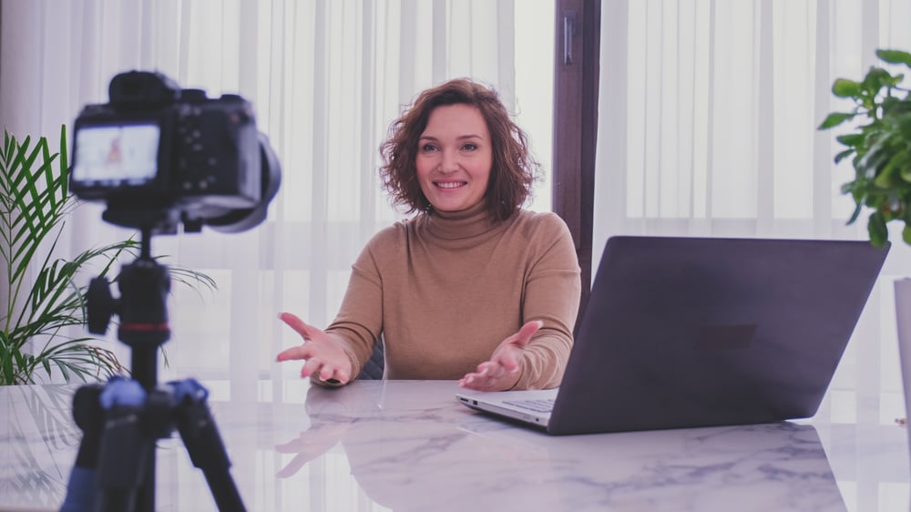 adult-woman-speaks-in-front-of-a-video-camera-for--59AERUD