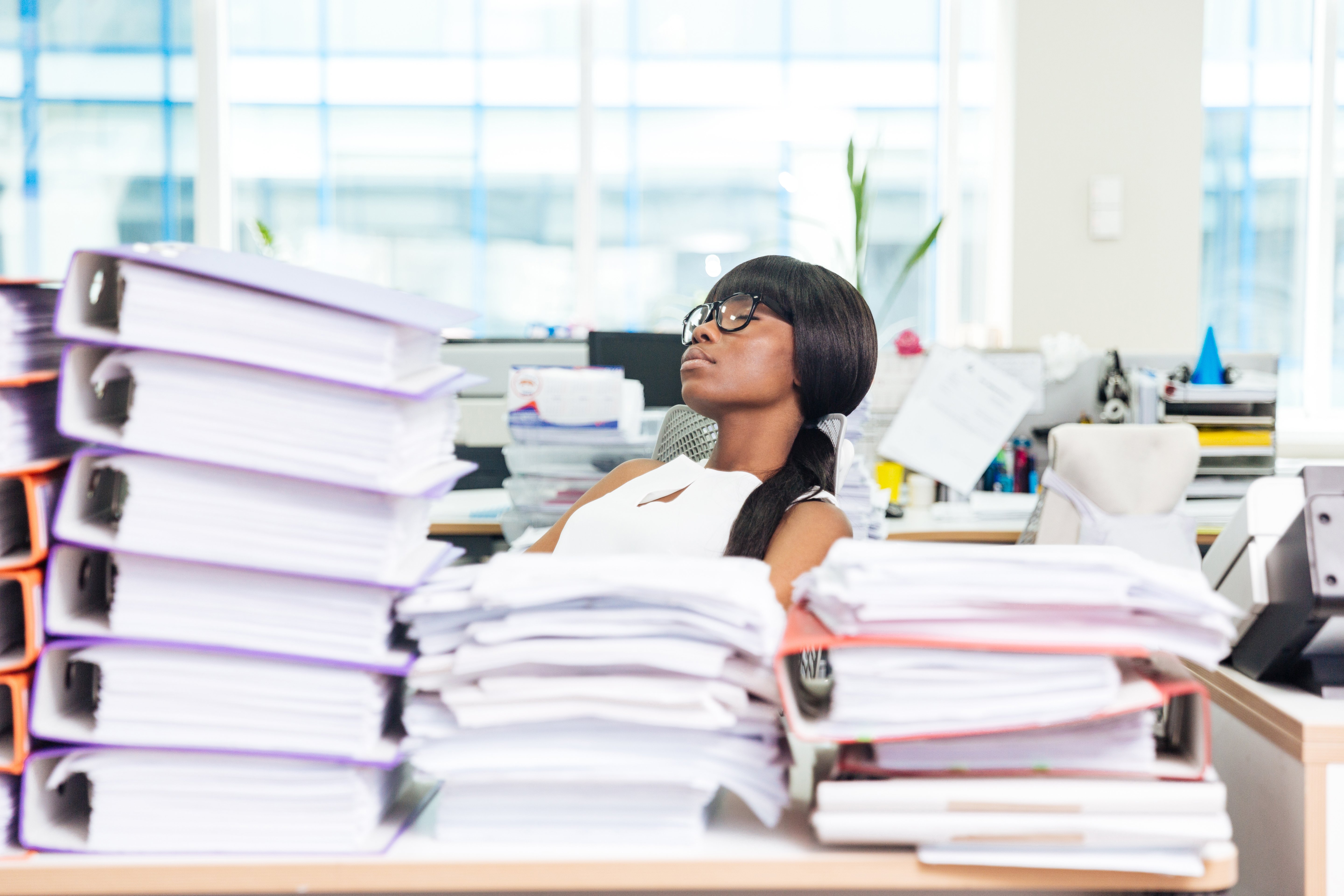 businesswoman-sleeping-in-office-with-many-work-P8JXKTP
