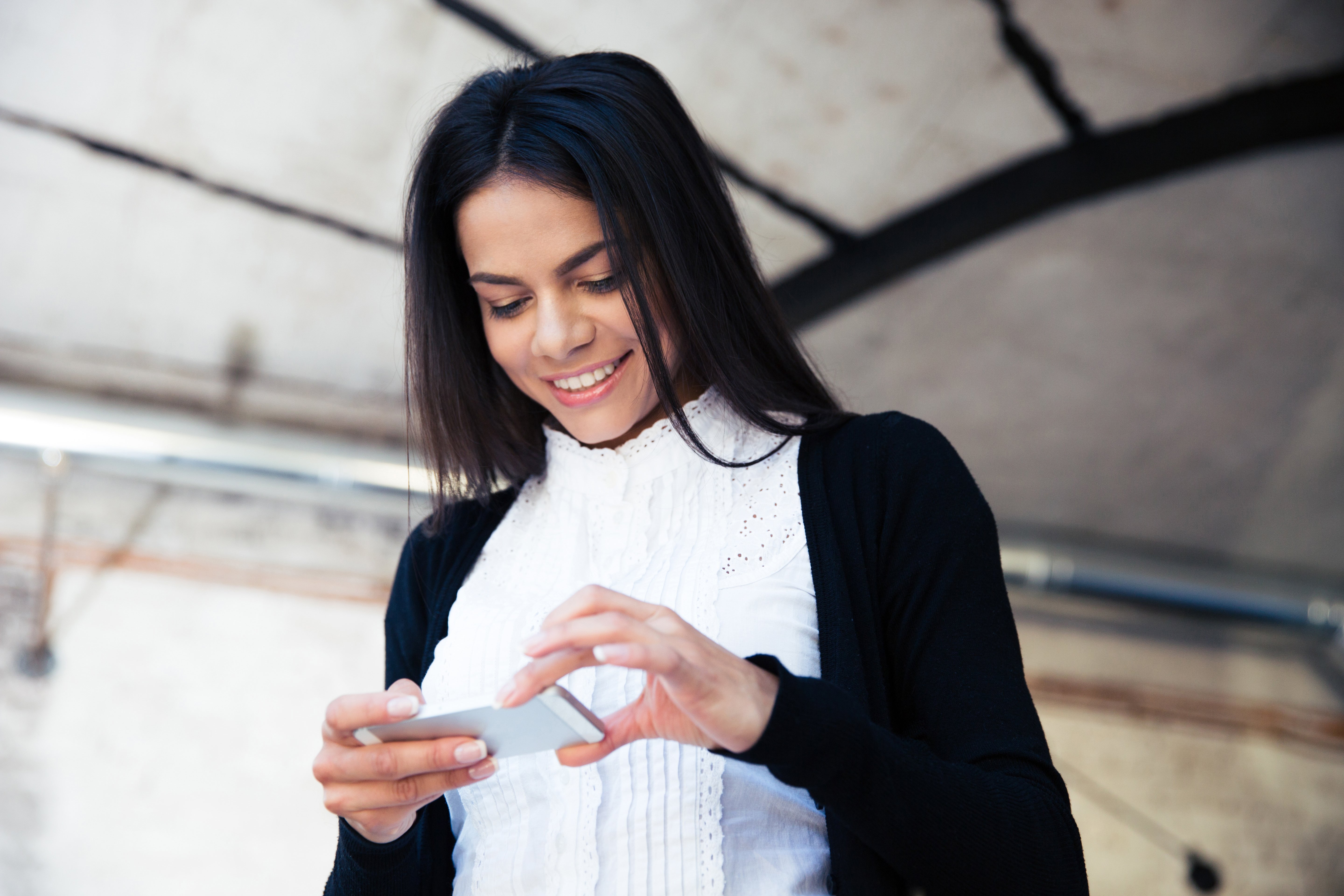 happy-businesswoman-using-smartphone-in-cafe-P9MSQMM