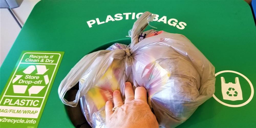 recycling-a-person-puts-many-plastic-grocery-bags-shopping-bags-and-other-plastic-wrap-to-be-recycled_t20_QzK6XE