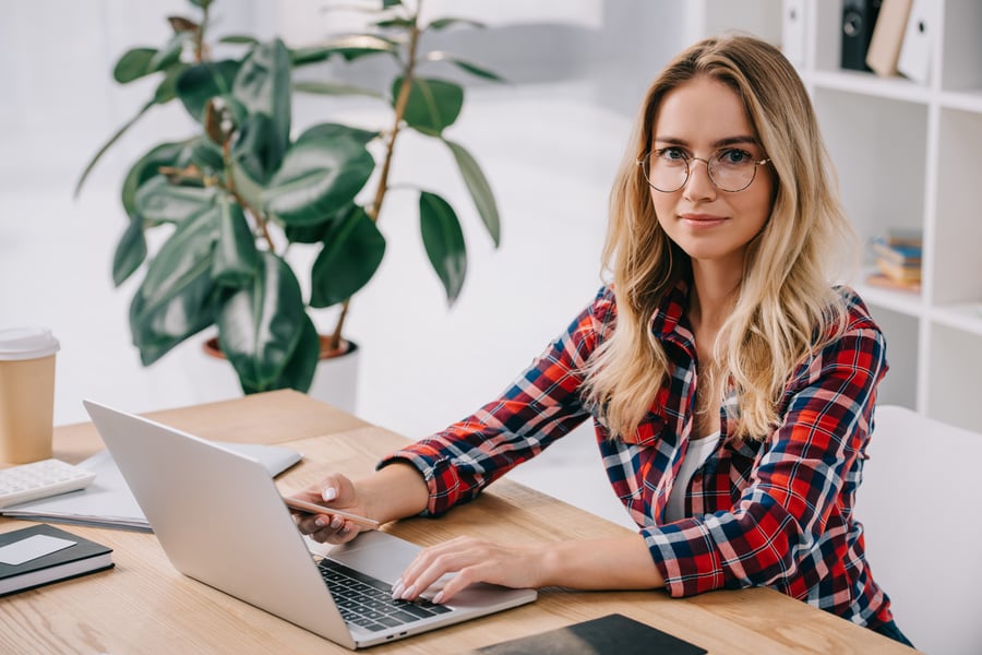smiling-woman-looking-at-camera-while-using-smartp-2021-08-30-01-49-46-utc