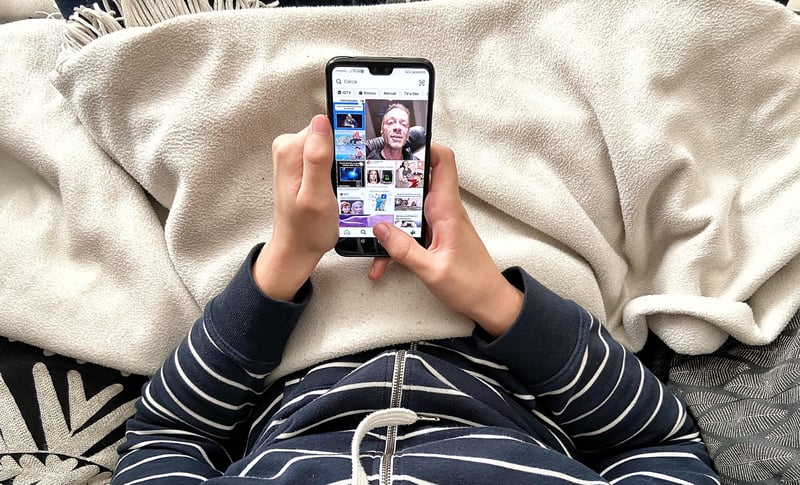 teenager-using-tik-tok-app-on-mobile-phone-laying-on-a-couch_t20_WgOmgX